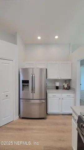 a kitchen with white cabinets and stainless steel appliances