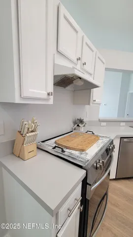 a kitchen with stainless steel appliances granite countertop a sink dishwasher stove and cabinets