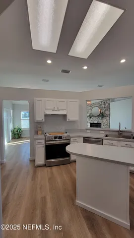 a kitchen with stainless steel appliances granite countertop a stove a sink and a refrigerator