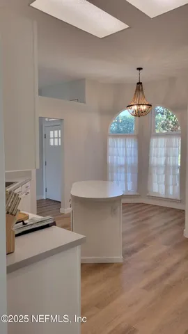 a kitchen view with granite countertop a stove and a wooden floor