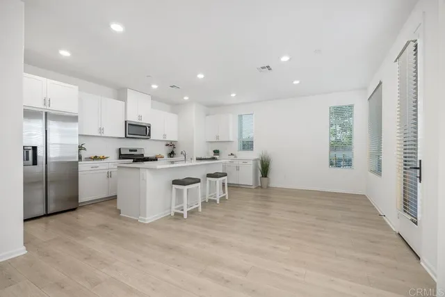 a kitchen with white cabinets and stainless steel appliances