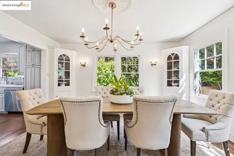 a kitchen with a stove a sink a dining table and chairs with wooden floor