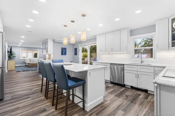a kitchen with kitchen island granite countertop a sink cabinets and wooden floor