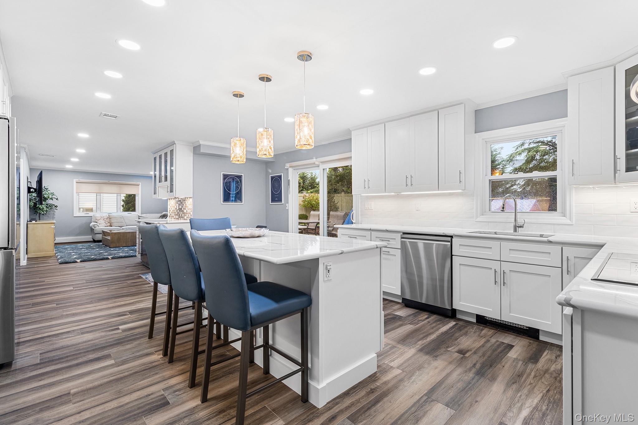 a kitchen with kitchen island granite countertop a sink cabinets and wooden floor