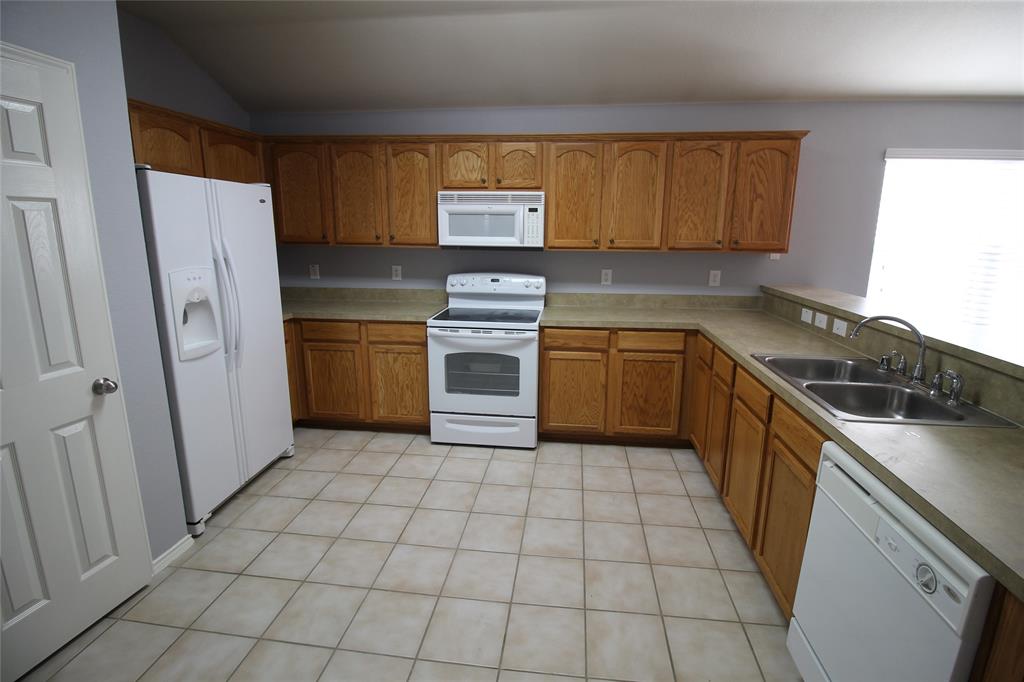 4188 Cherry Ridge Drive Frisco, TX 75033 - Photo 18 of 25 a kitchen with a stove a sink and a refrigerator