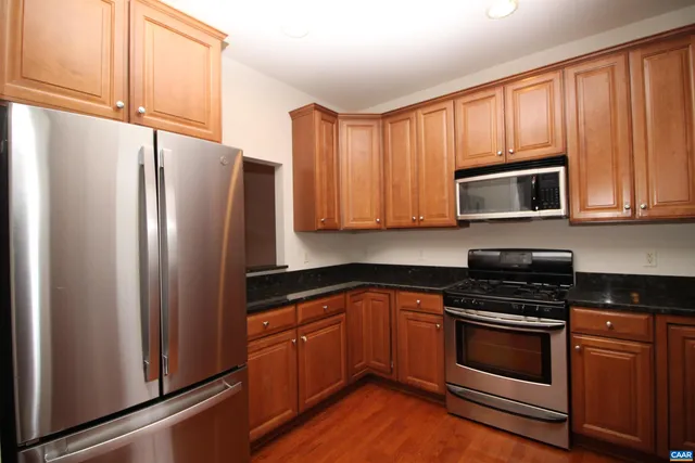 a kitchen with granite countertop a refrigerator stove and microwave