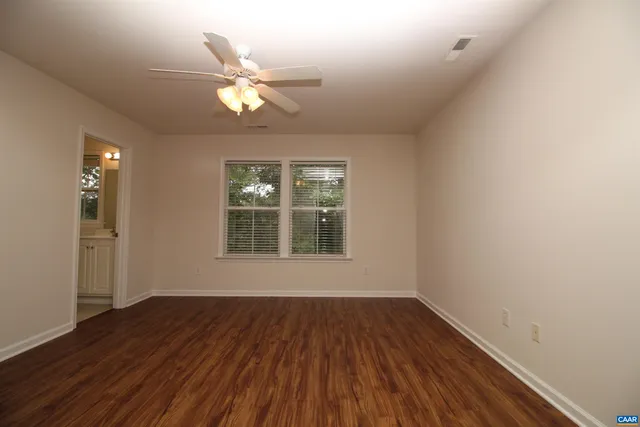 a view of wooden floor and a chandelier fan in a room