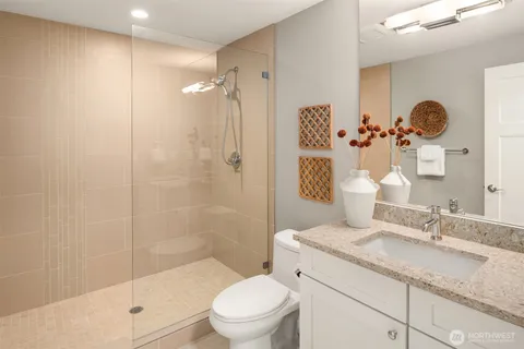 a bathroom with a granite countertop sink toilet and shower
