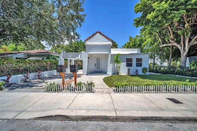 a view of a house with backyard and sitting area