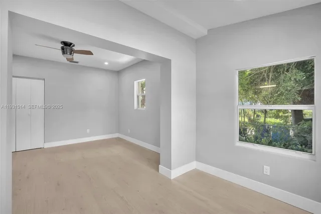 an empty room with a ceiling fan and a window