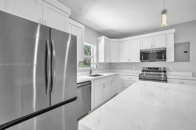 a kitchen with stainless steel appliances granite countertop a refrigerator and a sink