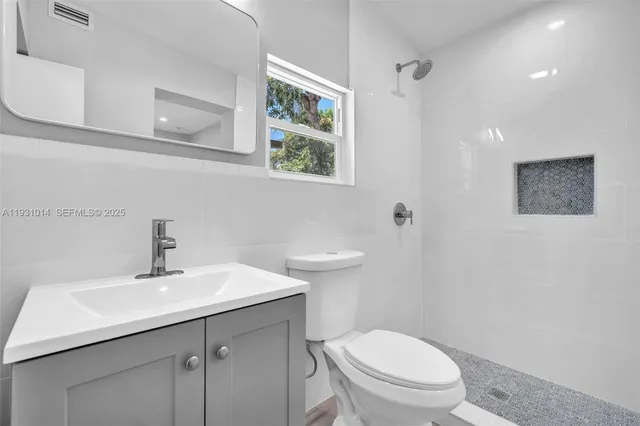 a bathroom with a toilet a sink and mirror