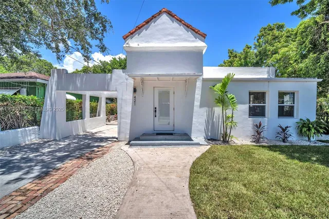 a view of a house with a yard and large tree