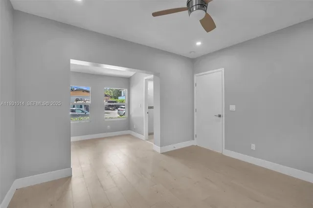 an empty room with windows and wooden floor