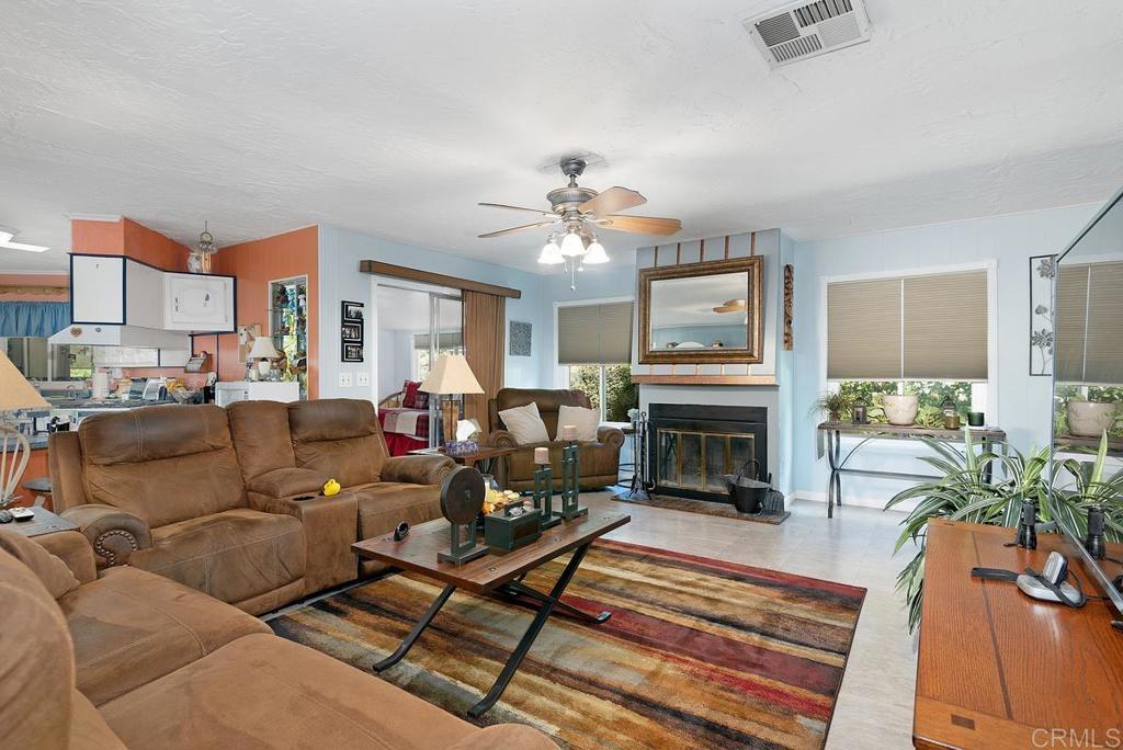 18218 Paradise Mountain Road Valley Center, CA 92082 - Photo 12 of 37 a living room with furniture a fireplace and a flat screen tv