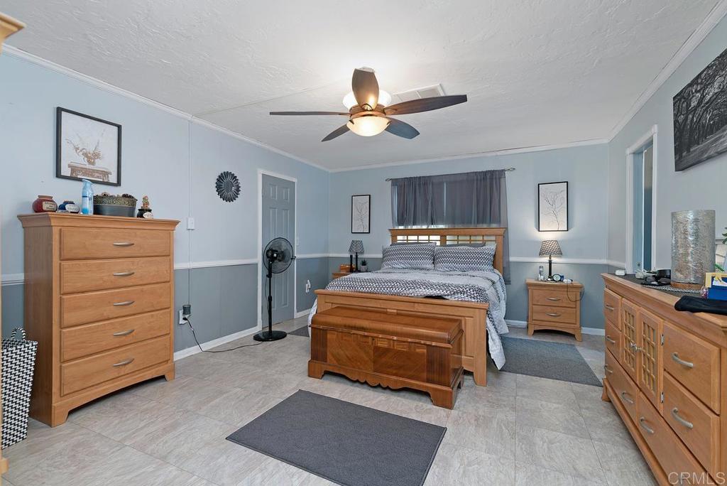 18218 Paradise Mountain Road Valley Center, CA 92082 - Photo 21 of 37 a bedroom with a bed and a chandelier