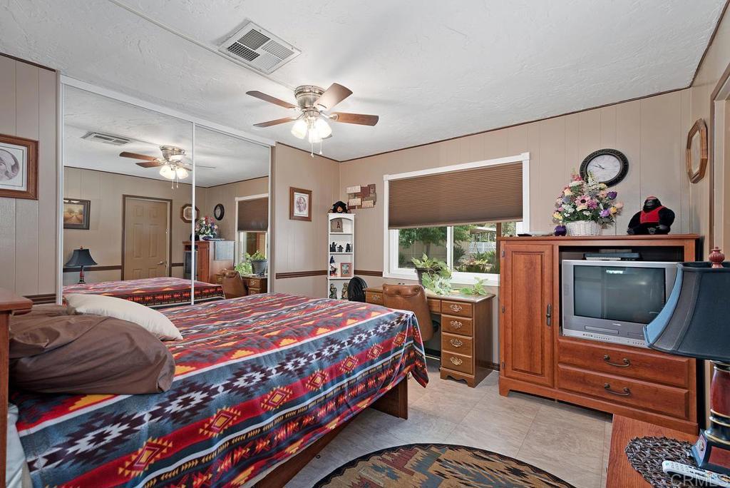 18218 Paradise Mountain Road Valley Center, CA 92082 - Photo 25 of 37 a bedroom with a bed and a flat screen tv