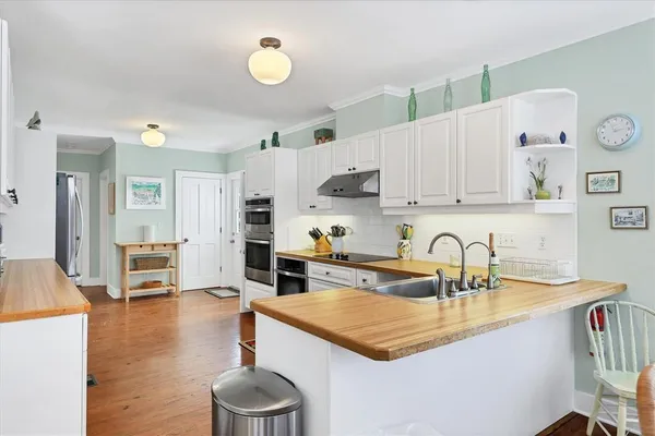 a kitchen with white cabinets and sink