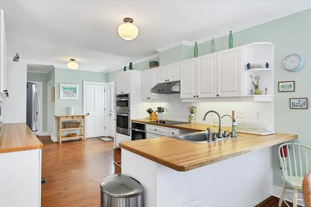 a kitchen with white cabinets and sink