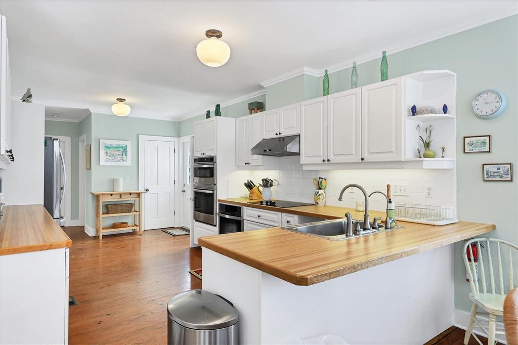 231 Gilchrist Avenue Boca Grande, FL 33921 - Photo 14 of 53 a kitchen with stainless steel appliances a sink a stove and a wooden floors