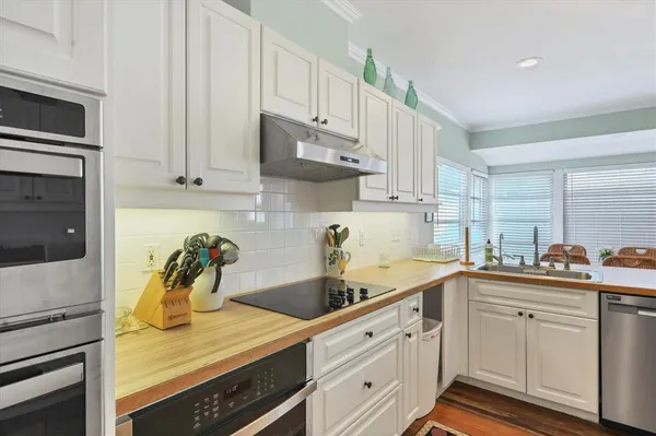 a kitchen with a white cabinets and wooden floor