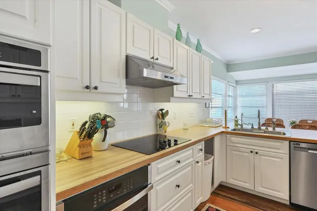 a kitchen with a white cabinets and wooden floor