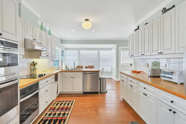 a kitchen with white cabinets and sink