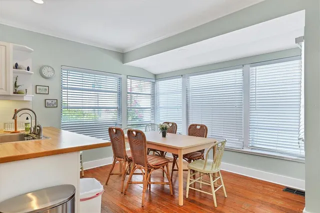 a view of a a dining room with furniture window and wooden floor