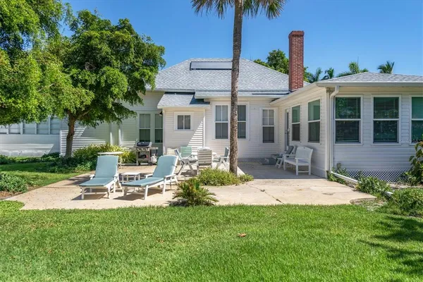a view of a house with backyard and sitting area