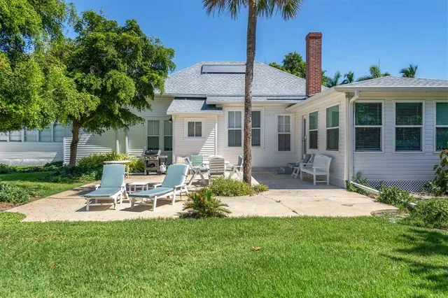 a view of a house with backyard and sitting area