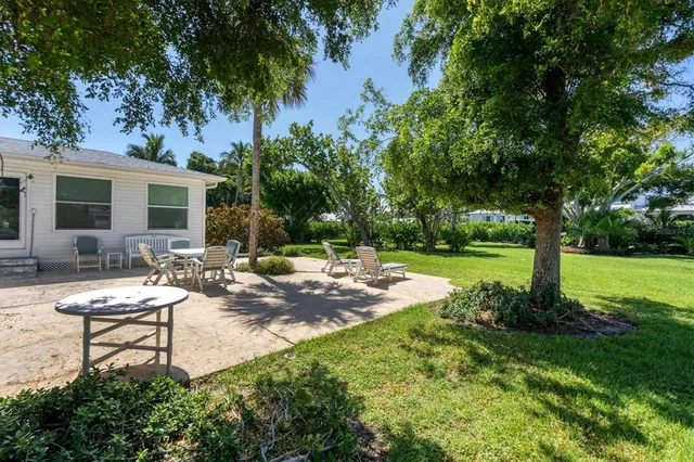 a view of a house with backyard and sitting area
