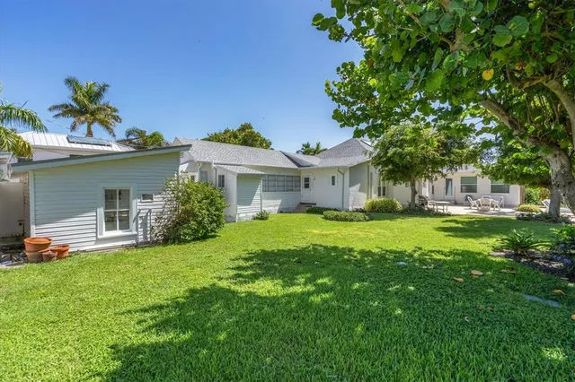 a view of a house with a big yard and potted plants