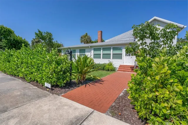 a view of a house with backyard and sitting area