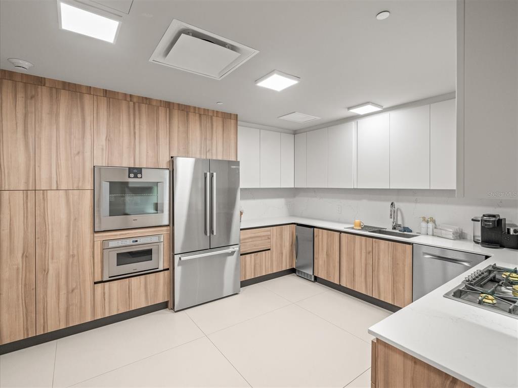 1020 Sunset Point Road, Unit 511 Clearwater, FL 33755 - Photo 50 of 99 a kitchen with granite countertop white cabinets and stainless steel appliances