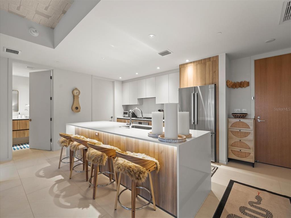 1020 Sunset Point Road, Unit 511 Clearwater, FL 33755 - Photo 61 of 99 a kitchen with stainless steel appliances kitchen island granite countertop a refrigerator and a stove