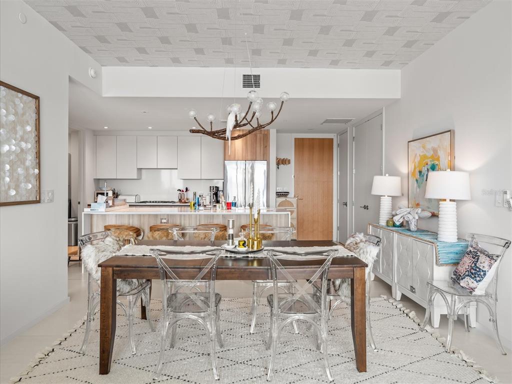 1020 Sunset Point Road, Unit 511 Clearwater, FL 33755 - Photo 69 of 99 a kitchen with kitchen island granite countertop a table and chairs in it