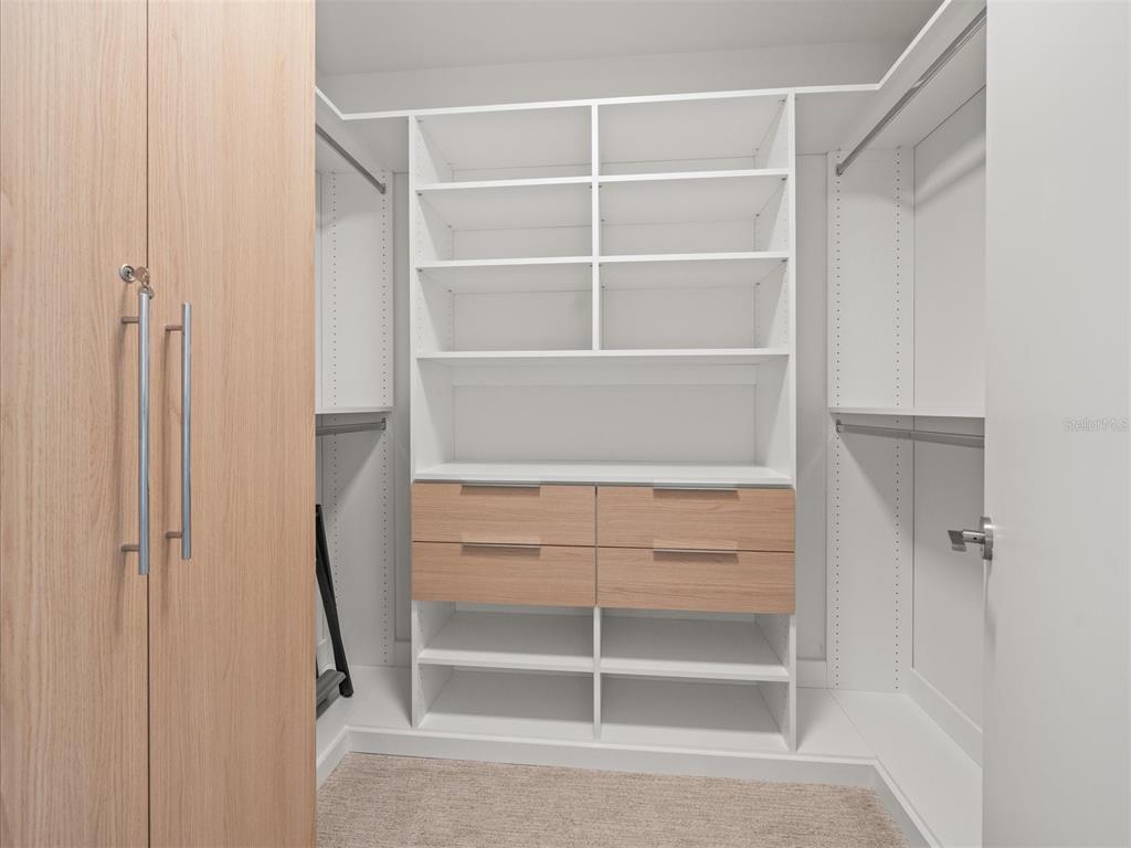 1020 Sunset Point Road, Unit 511 Clearwater, FL 33755 - Photo 91 of 99 a view of walk in closet with empty racks