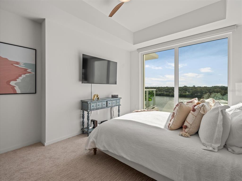 1020 Sunset Point Road, Unit 511 Clearwater, FL 33755 - Photo 95 of 99 a bedroom with a bed and a flat tv screen on dresser