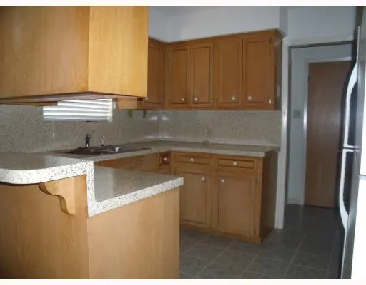 a kitchen with a sink a refrigerator and cabinets