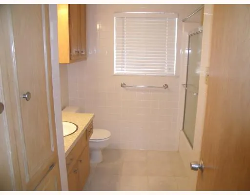 a bathroom with a granite countertop toilet and a sink