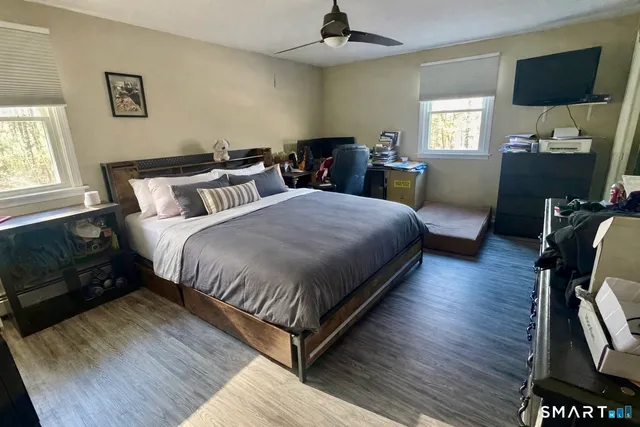 a bedroom with a bed and wooden floor