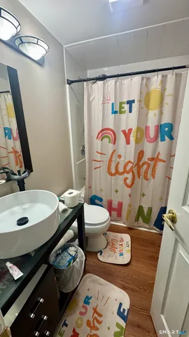 a bathroom with a toilet sink and mirror