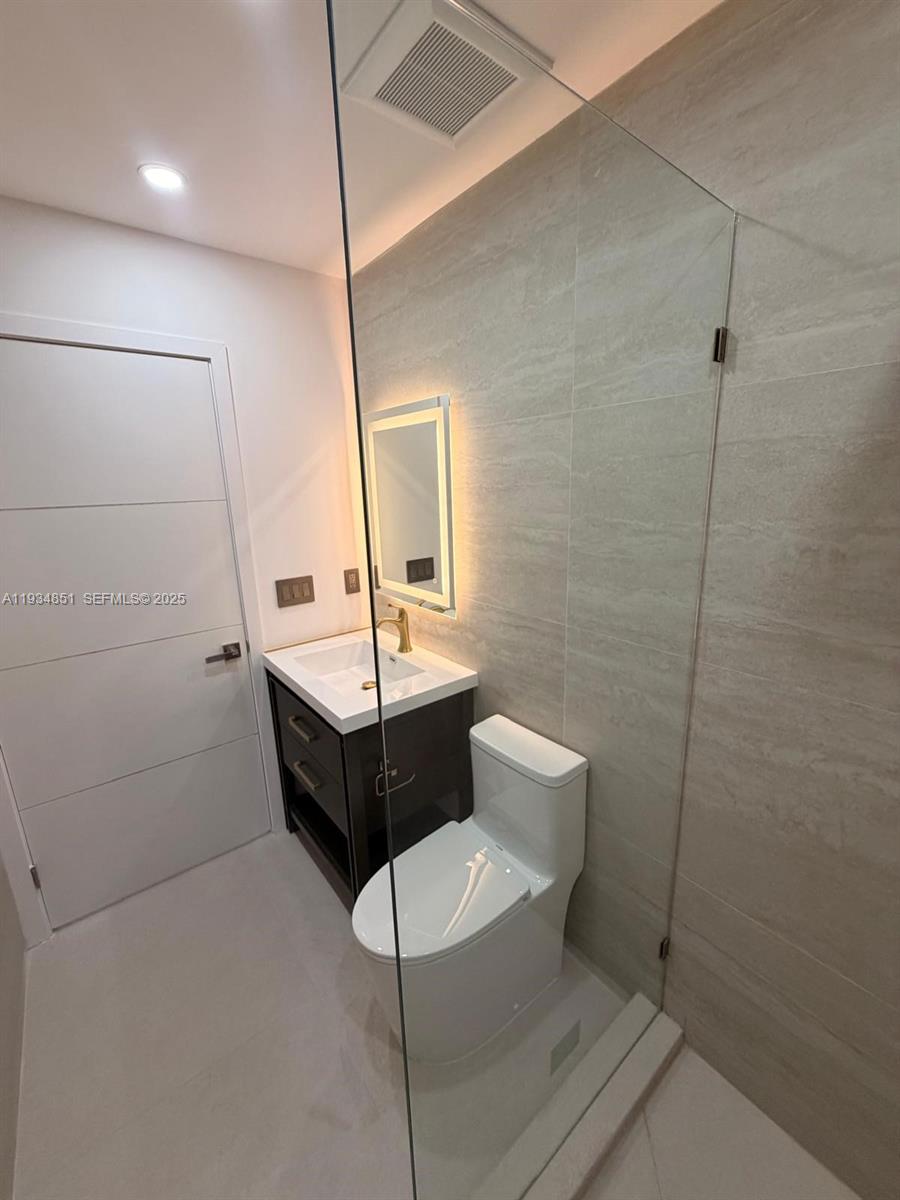 2436 Southwest 7th Street, Unit 4 Miami, FL 33135 - Photo 2 of 17 a bathroom with a sink a toilet and mirror