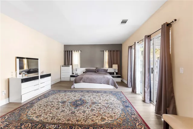 a large bedroom with a large bed rug and wooden floor