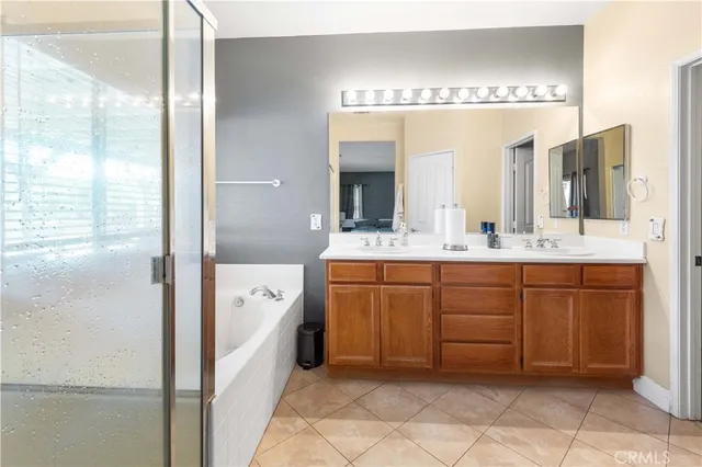 a spacious bathroom with a double vanity sink a mirror and a bathtub