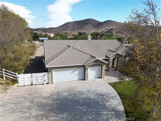 a view of a white house next to a yard with mountain