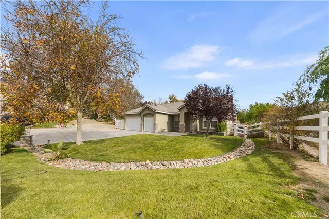 a view of a house with a big yard and large trees