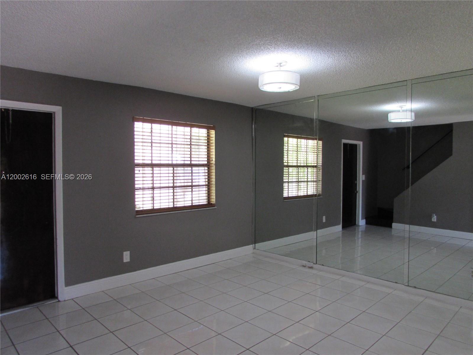 5555 Ludlam Road, Unit 23 South Miami, FL 33155 - Photo 3 of 25 a view of an empty room with window and chandelier fan