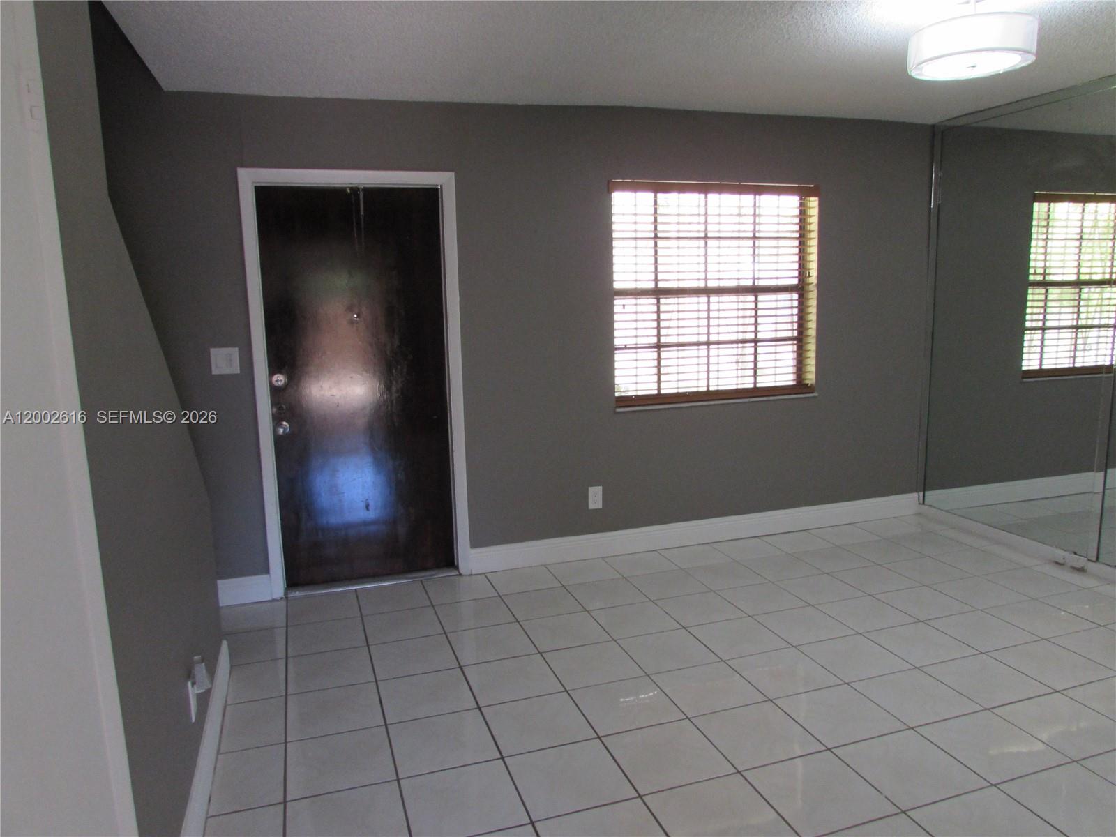 5555 Ludlam Road, Unit 23 South Miami, FL 33155 - Photo 4 of 25 an empty room with windows and closet