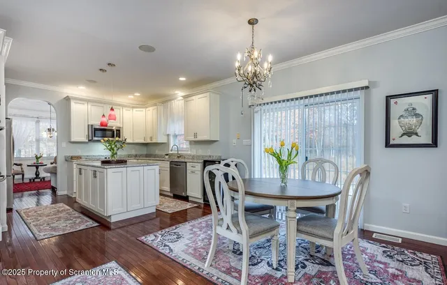 a view of a dining room with furniture and a chandelier